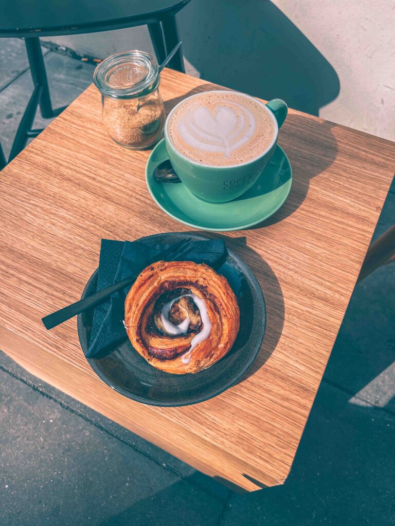 Heart shaped latte art and a cinnamon bun at Copenhagen Coffee Lab