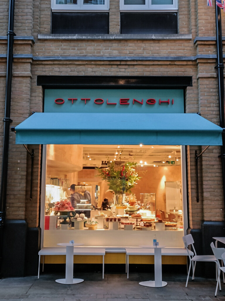 Exterior of Ottolenghi Marylebone in London with cozy blue awnings.