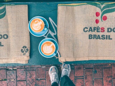 Flatlay of two amazing cups of coffee with latte art and seats made out of coffee bags