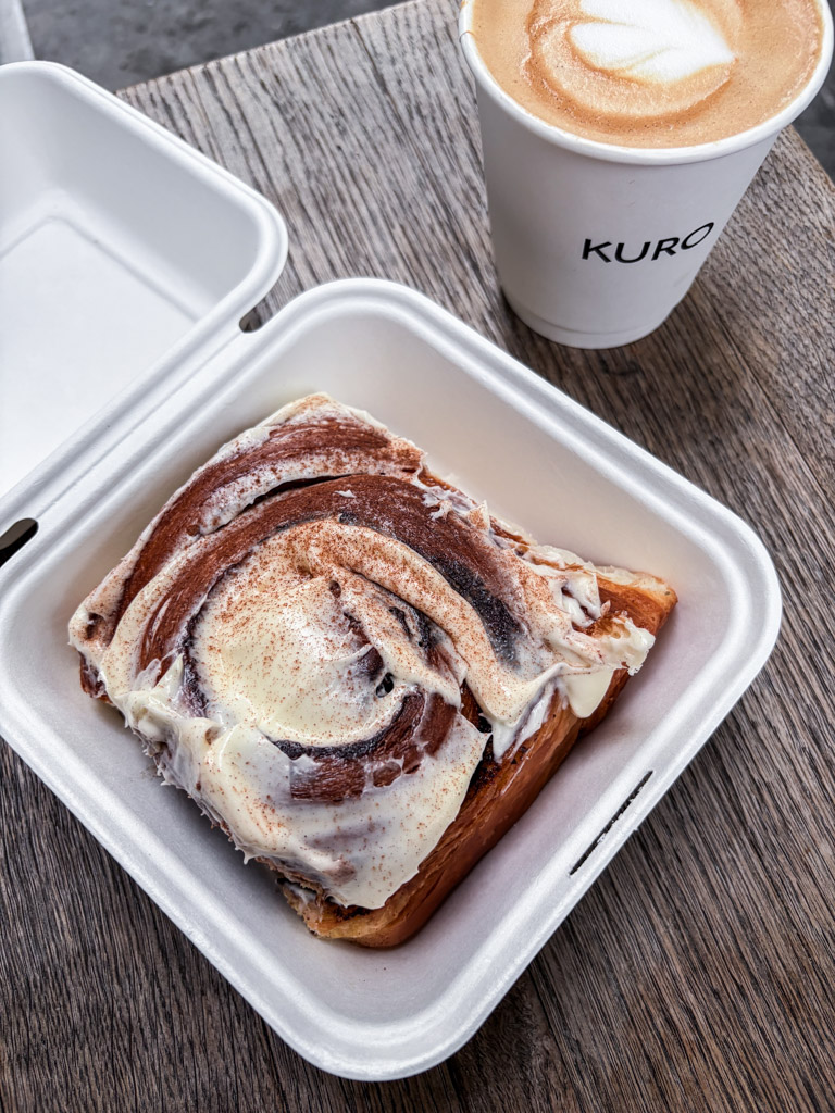 A cinnamon bun and a coffee at Kuro bakery in London